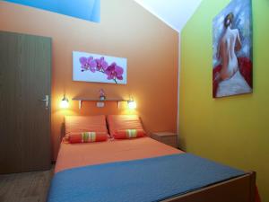 a bedroom with a bed with orange and green walls at House Vodnjan 2106 in Vodnjan