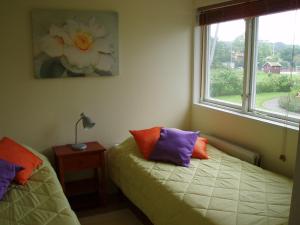um quarto com 2 camas, uma janela e uma mesa em Nösund Holiday Home em Nösund