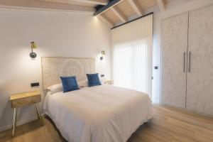 una camera da letto con un grande letto bianco con cuscini blu di Villa Valentina a Rales
