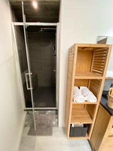 uma casa de banho com chuveiro e uma prateleira com toalhas em Appartement Idéal en centre ville em Montpellier
