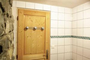 een badkamer met een houten deur in een kamer bij Appart Saint-Antoine Morzine vue soleil jardin calme parking 2 à 4 pers in Morzine