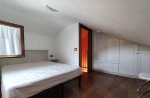 a white bedroom with a bed and a window at DA ELENA in Castel di Sangro