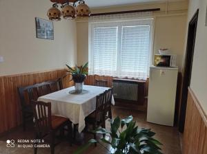 a dining room with a table and a refrigerator at Liget Fruit Garden in Zalakaros