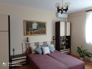 sypialnia z łóżkiem i obrazem na ścianie w obiekcie Liget Fruit Garden w Zalakaros