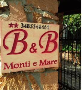 um sinal para um bar e um mourice numa parede de pedra em Monti e Mare em Lanusei