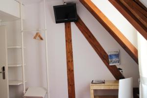 a small room with a tv and a shelf at Zunfthaus zur Rebleuten in Chur