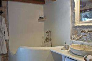 Baño blanco con bañera y lavamanos en Critamo cottage, en Gavalochori