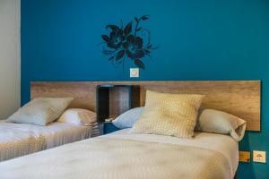 ein Schlafzimmer mit 2 Betten und einer blauen Wand in der Unterkunft Hostal La Pastora in Candeleda