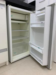 um frigorífico branco com a porta aberta numa cozinha em Hotel Cavalinho Branco - Apartamento 136 em Águas de Lindoia