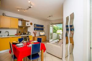 a kitchen and dining room with a red table and chairs at Appartamento Aurora in Riva del Garda