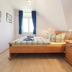 a bedroom with a bed with blue curtains and a window at Das Landhaus am Haff B10 in Stolpe