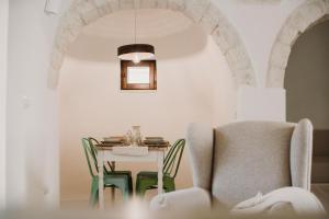 uma sala de jantar com mesa e cadeiras em VENTITRÈ- House of Apulia Mea em Alberobello