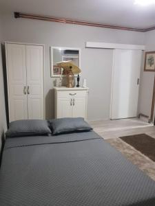 a bedroom with a bed and white cabinets at vila Nikolaj in Niš