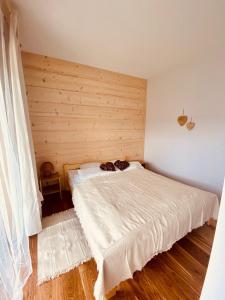 sypialnia z łóżkiem i drewnianą ścianą w obiekcie ROZTOKI Four Seasons w mieście Witów