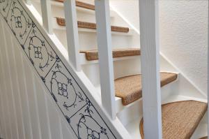 una escalera de caracol con una tabla de surf en las escaleras en Ferienhaus Kleiner Siedler, en Bremerhaven