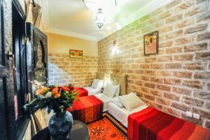 um quarto com 2 camas e uma parede de tijolos em Riad Errabii & Spa em Marrakech