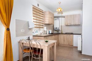 a kitchen with a wooden table and chairs at Apartament Carpe Diem Brasov in Braşov