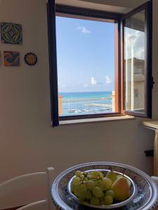 un plato de fruta en una mesa frente a una ventana en La Suite di Dolores, en Balestrate