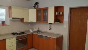 a kitchen with wooden cabinets and a sink and a stove at Apartments Boćin Rosso in Hvar