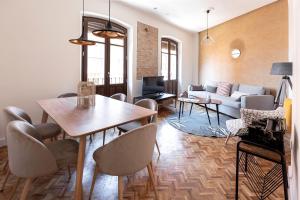 sala de estar con mesa y sofá en Apartamentos PROGRESO en Granada