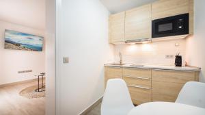 a kitchen with white cabinets and white chairs at Etti Paradise - Suite La Luna in Pájara