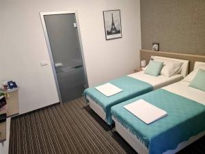 a hotel room with two beds and a bathroom at BoNiToS, SOBE-ROOMS in Slavonski Brod