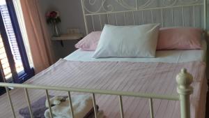 アイワルクにあるMelekler Pansiyonのベッド(ピンクと白の枕、犬の寝具付)