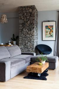 a living room with a gray couch and a table at Karolinka Guest House in Szczyrk