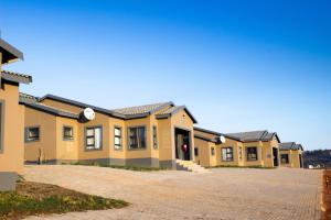 una fila de casas amarillas con entrada en Ndalo Lodge Oshoek, 