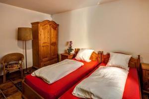 two beds in a room with a red blanket at Chata Pelikán in Loučná nad Desnou