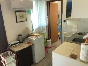 a kitchen with a white refrigerator and a sink at Apartman Juliana in Stara Novalja