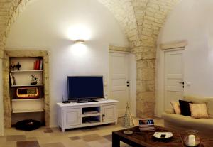 a living room with a tv on a white cabinet at La Vecchia Tabaccheria B&B in Ostuni