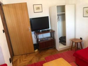 a living room with a television and a door at Apartman Juliana in Stara Novalja