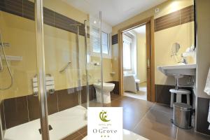 a bathroom with a toilet, sink, and shower at Hotel Spa Norat O Grove 3* Superior in O Grove
