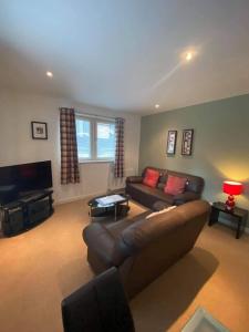 a living room with a couch and a television at Dreamhouse at Oswald Street, City Centre in Glasgow