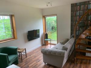 a living room with a couch and a television at Landelijk en toch centraal, eigen keuken en veel privacy in Bleiswijk