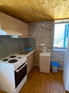 eine kleine Küche mit Herd und Spüle in der Unterkunft Soldatos Stone House in Katokhórion