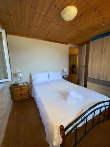 Schlafzimmer mit einem großen weißen Bett und einer Holzdecke in der Unterkunft Soldatos Stone House in Katokhórion