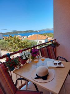 una mesa con dos vasos y un sombrero en el balcón en Apartments Gracia & Toni, en Trogir