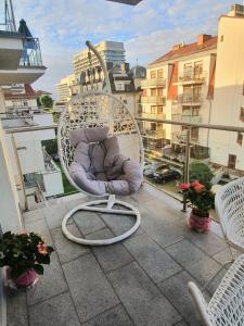 uma cadeira branca sentada em cima de uma varanda em Stella Baltic big terrace 3 Zimmer frei parking em Świnoujście