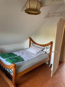 a small bed in a room with a ceiling at Namelis - pirtelė in Plateliai