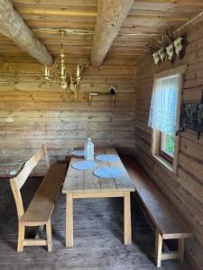 uma sala de jantar em madeira com uma mesa e cadeiras em madeira em Namelis - pirtelė em Plateliai