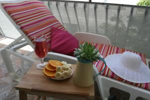 een tafel met pannenkoeken en een drankje en een vaas op een stoel bij Apartman Mare in Makarska