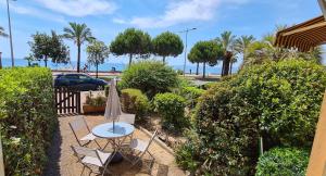 a patio with a table and chairs and the beach at Studio de la plage - Mer, Terrasse et garage in Cagnes-sur-Mer