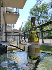 two wine glasses and a bottle of wine on a table at Apartament Matejki 17 - Insel Apartamenty in Świnoujście