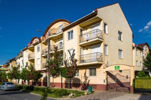 an apartment building with balconies on a street at Lux Apartmanok in Hajdúszoboszló