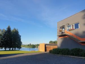 a building with a balcony with a view of a river at Ilmatsalu Motell in Ilmatsalu