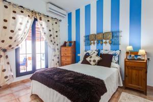 a bedroom with blue and white striped walls and a bed at Casa Delfín Playa Blanca 2 dormitorios y piscina in Playa Blanca +14 photos