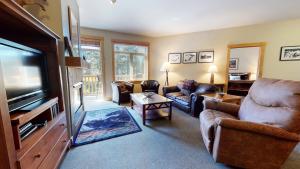 a living room with couches and a flat screen tv at Sunstone #322 condo in Mammoth Lakes