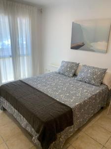 een slaapkamer met een bed en een schilderij aan de muur bij apartamento centrico silencioso in Nerja
